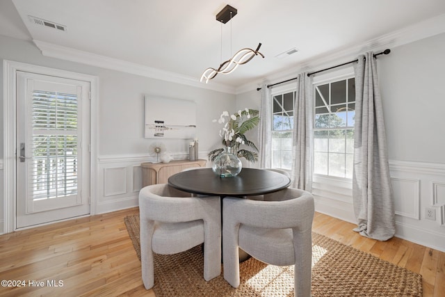 dining area featuring light hardwood / wood-style floors and ornamental molding