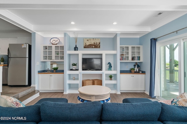 living room with ornamental molding and light hardwood / wood-style floors