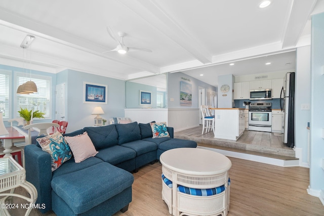 living room with beam ceiling, light hardwood / wood-style flooring, and ceiling fan