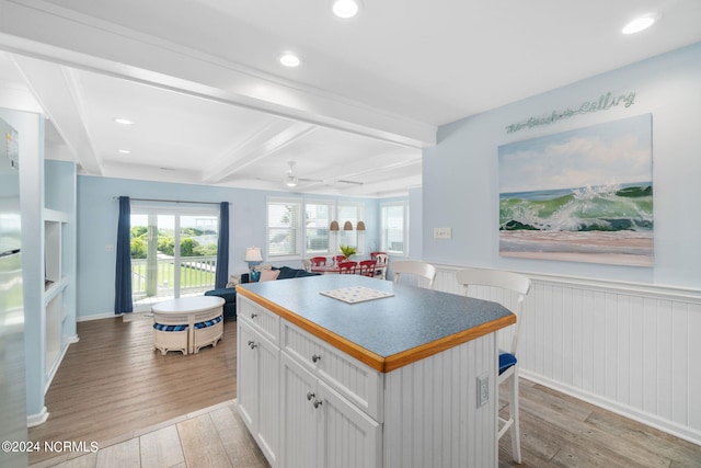 kitchen featuring light hardwood / wood-style flooring, a kitchen breakfast bar, a kitchen island, and white cabinets