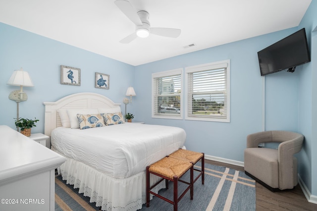 bedroom with dark hardwood / wood-style floors and ceiling fan