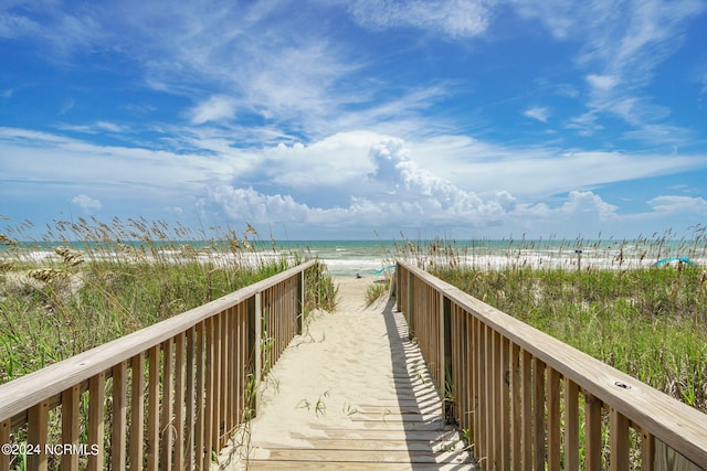 view of home's community with a water view and a beach view