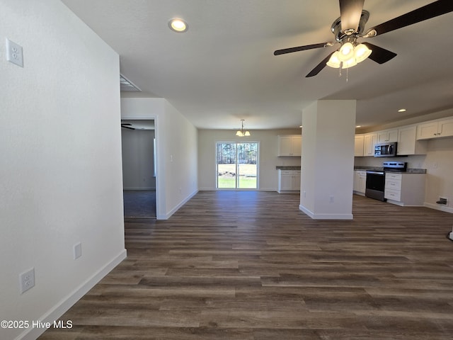 unfurnished living room with ceiling fan with notable chandelier and dark hardwood / wood-style floors