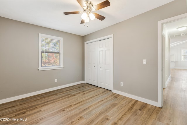 unfurnished bedroom with a closet, light hardwood / wood-style floors, and ceiling fan