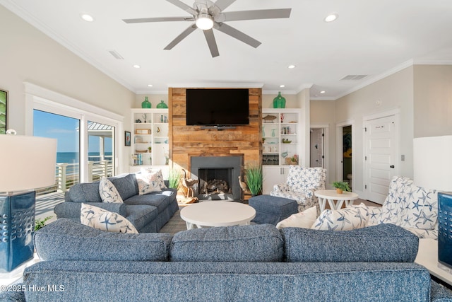 living room with ceiling fan, ornamental molding, and a fireplace