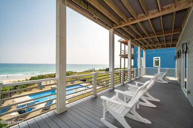 wooden terrace with a view of the beach and a water view