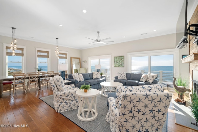 living room with crown molding, a water view, and dark wood-type flooring