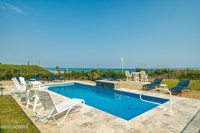 view of pool with a patio and a water view