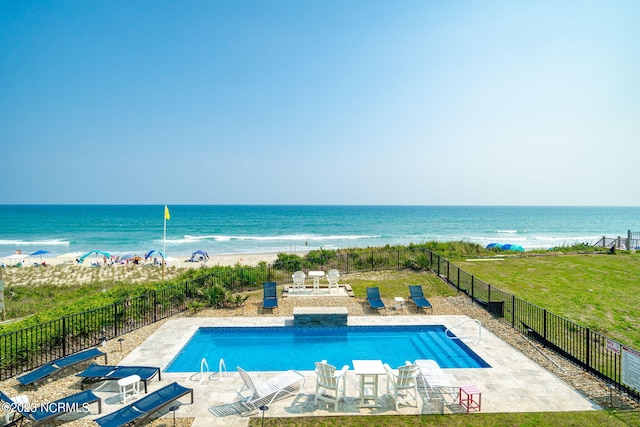 view of swimming pool with a yard, a patio area, and a water view