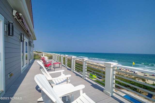 wooden terrace with a water view and a view of the beach