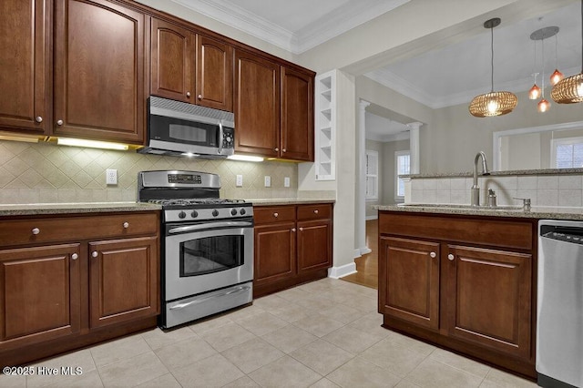 kitchen with ornamental molding, appliances with stainless steel finishes, a sink, and decorative light fixtures