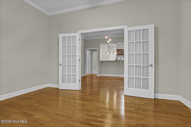 empty room featuring ornamental molding, french doors, and wood finished floors