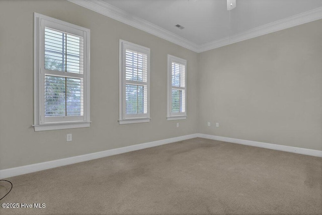 carpeted empty room with baseboards, ornamental molding, visible vents, and a healthy amount of sunlight