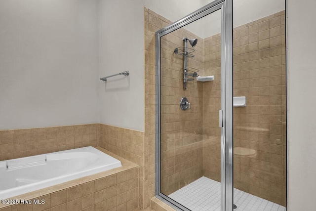 bathroom featuring a garden tub and a shower stall