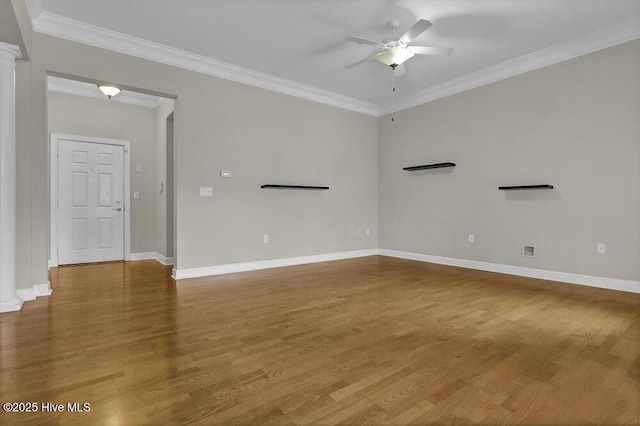 spare room with ornate columns, crown molding, and wood finished floors