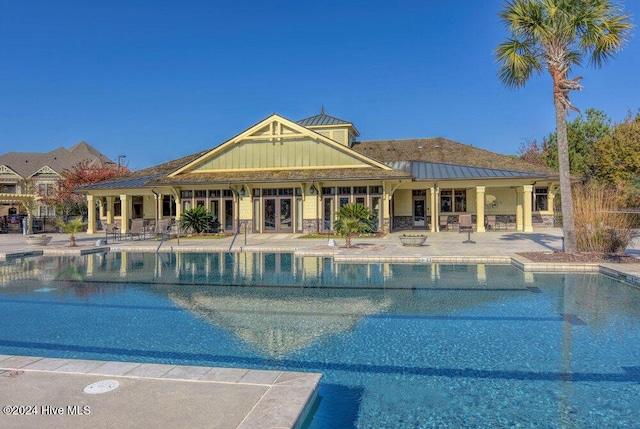 pool with french doors and a patio area