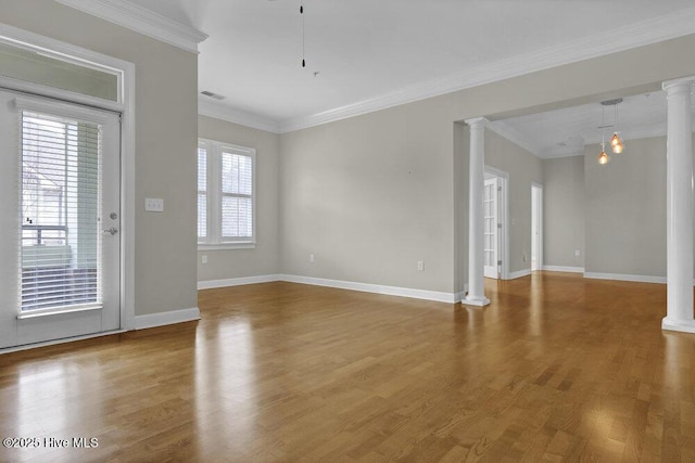 spare room featuring crown molding, visible vents, decorative columns, and wood finished floors