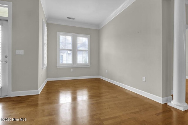 foyer with wood finished floors, visible vents, baseboards, ornamental molding, and decorative columns