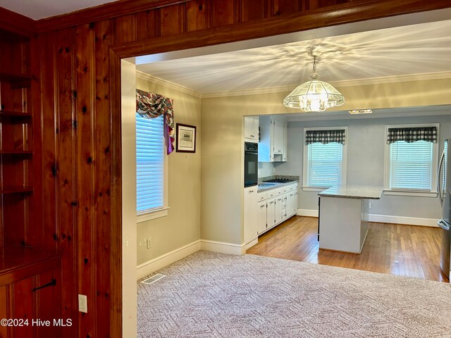 kitchen featuring ornamental molding, pendant lighting, white cabinets, oven, and light hardwood / wood-style flooring