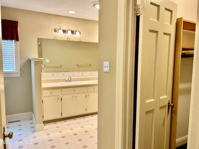 bathroom with vanity and a textured ceiling