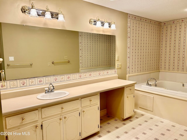 bathroom with a washtub, vanity, and a textured ceiling