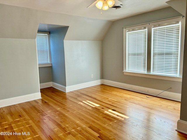 additional living space with ceiling fan, light wood-type flooring, and vaulted ceiling