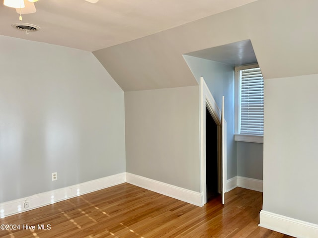 additional living space featuring wood-type flooring, ceiling fan, and lofted ceiling