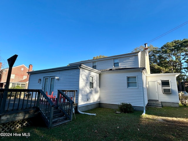 rear view of house with a wooden deck and a lawn