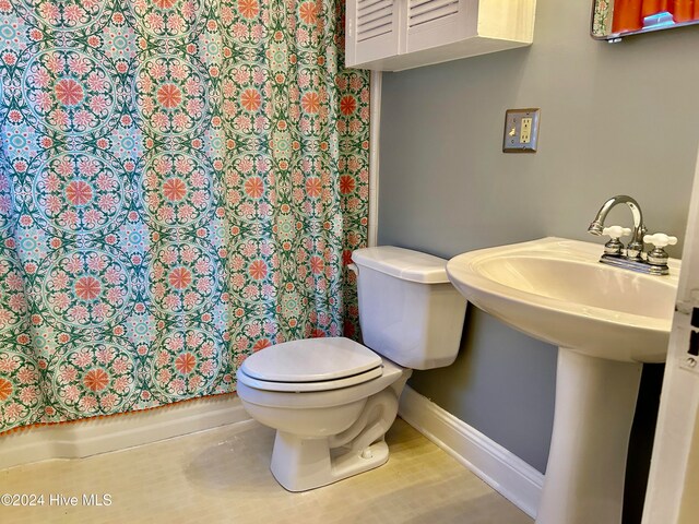 bathroom with toilet, sink, and hardwood / wood-style floors