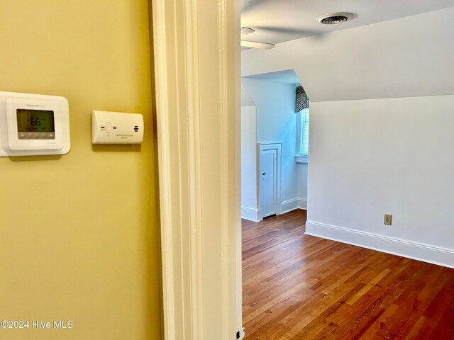 hallway with hardwood / wood-style floors and lofted ceiling