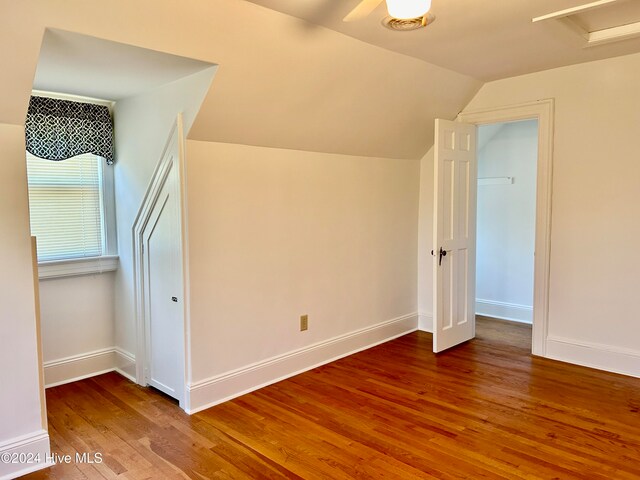 additional living space with hardwood / wood-style floors and vaulted ceiling