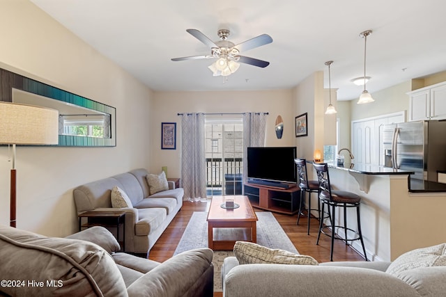 living room featuring dark wood-type flooring, a wealth of natural light, and ceiling fan