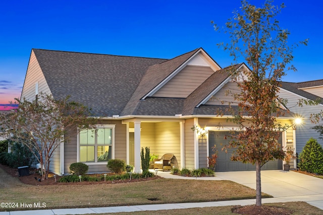 view of front of home with a yard and a garage