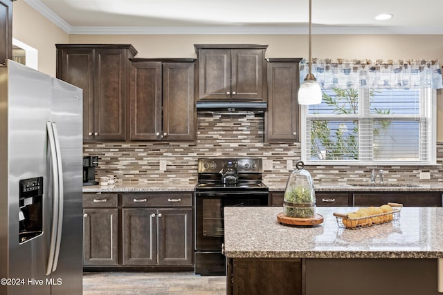 kitchen with electric range, dark brown cabinets, under cabinet range hood, stainless steel refrigerator with ice dispenser, and a sink