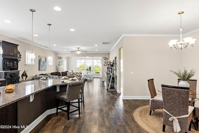 kitchen with light stone counters, dark wood-type flooring, visible vents, open floor plan, and crown molding