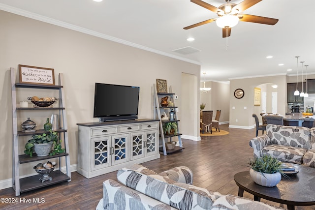 living room with dark wood-style floors, arched walkways, visible vents, ornamental molding, and baseboards