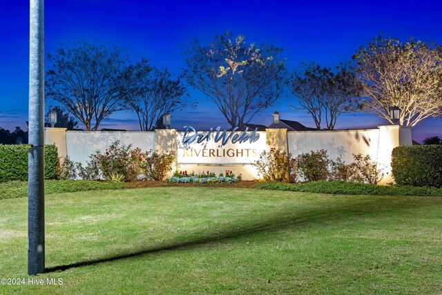 back house at dusk with a lawn and a patio