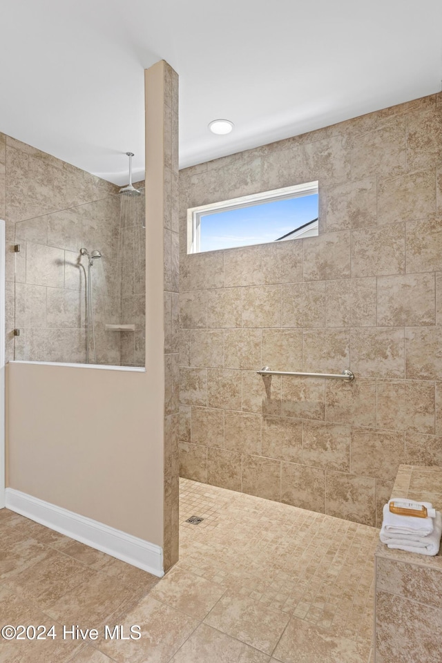 bathroom featuring a walk in shower and baseboards