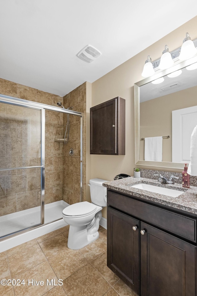 bathroom featuring toilet, a stall shower, visible vents, and vanity