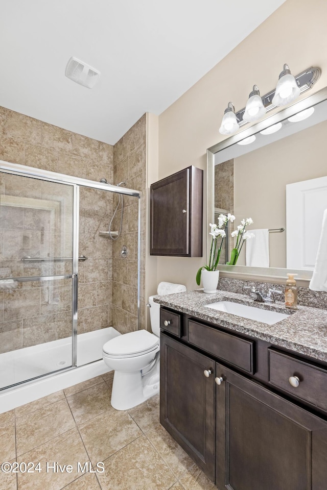 bathroom featuring visible vents, toilet, a shower stall, and vanity