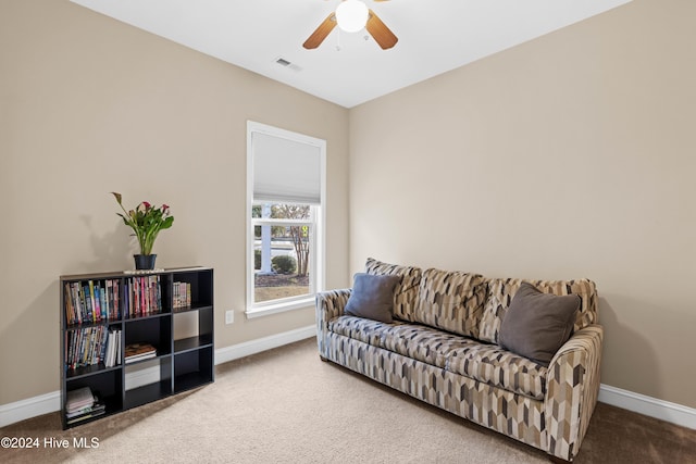 living area with carpet floors, baseboards, visible vents, and ceiling fan