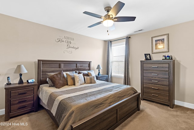 bedroom with baseboards, a ceiling fan, visible vents, and light colored carpet