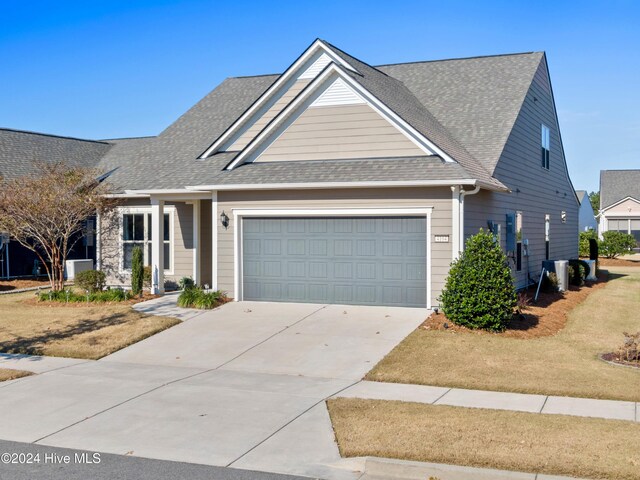 back of property with a shingled roof, a patio area, and a yard