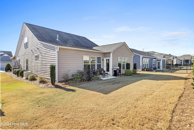 back of property featuring a yard, fence, and a patio