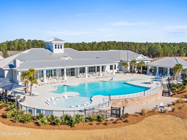 community pool featuring a patio, a community hot tub, and fence