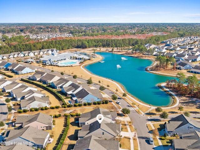 drone / aerial view with a residential view, a water view, and a wooded view