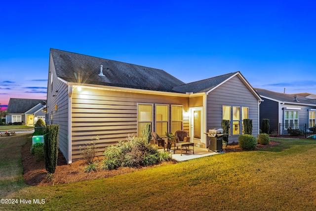 back of house featuring a lawn and a patio area