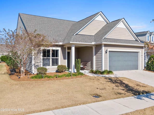 view of front of property with driveway, a shingled roof, and an attached garage