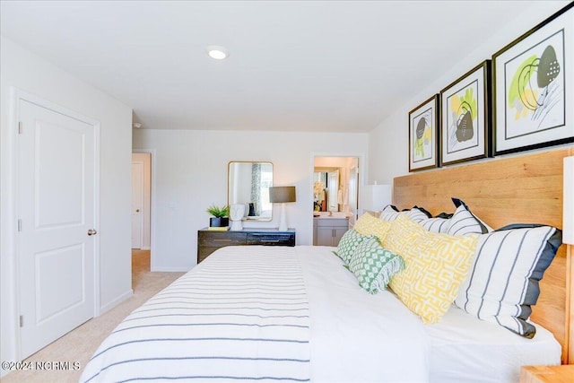 bedroom featuring light colored carpet and ensuite bath