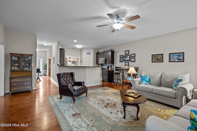 living room with ceiling fan and dark hardwood / wood-style floors